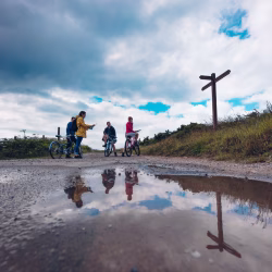Reflections in puddle, cyclists, Alderney